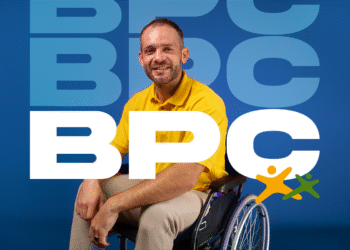 homem cadeirante sorrindo em frente ao fundo azul com a sigla BPC