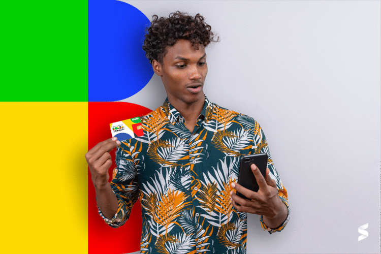 Pessoa segurando cartão do Bolsa Família e consultando o celular, ilustrando o tema do bloqueio do benefício.