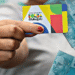 Cartão Bolsa Família e notas de 100 reais, representando o calendário de pagamentos de maio de 2025.