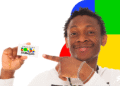 Homem sorridente segurando cartão do programa Bolsa Família com fundo colorido.