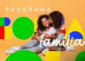 Mãe abraçando e beijando filha sorridente com elementos gráficos do Bolsa Família ao fundo.