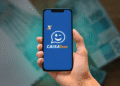 Mão segurando celular com aplicativo Caixa Tem aberto na tela