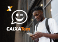 Jovem homem usando celular com logo do aplicativo Caixa Tem ao lado.