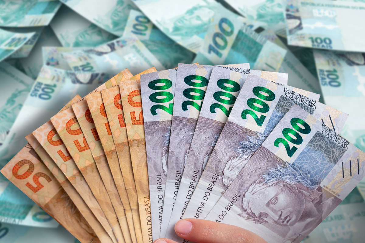 Notas de R$50, R$100 e R$200 empilhadas representando o pagamento do PIS/Pasep