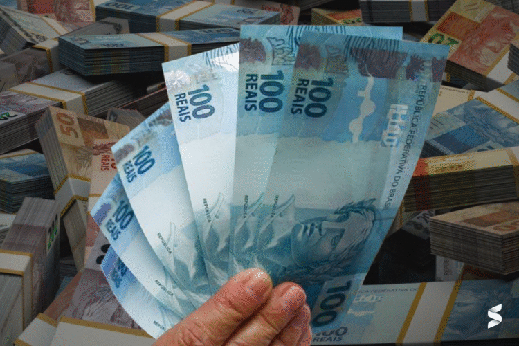 Cédulas de 100 reais destacadas ao fundo de notas de dinheiro, ilustrando o impacto financeiro do Auxílio Gás no Bolsa Família