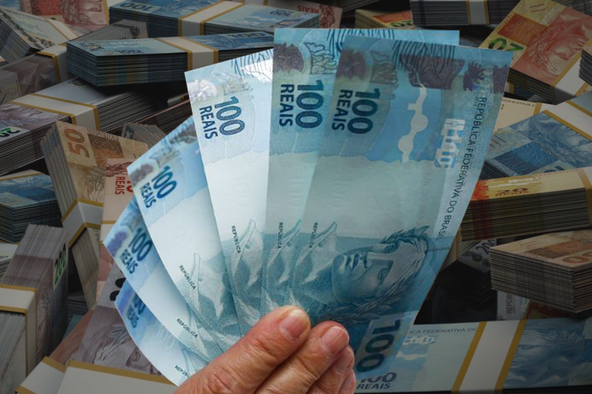 Notas de 100 reais com pilhas de dinheiro ao fundo, representando o pagamento do Auxílio Gás.