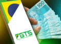 Celular com logo do FGTS e notas de R$ 100, representando o Saque de Calamidade