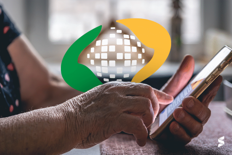 Mão de um idoso segurando um smartphone, com o logo do INSS sobreposto na imagem.