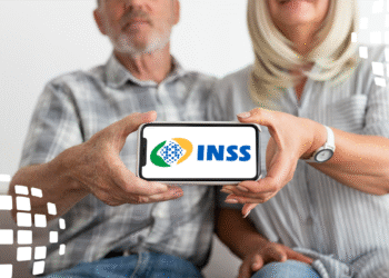 Casal idoso exibindo logo do INSS no celular, representando devolução de R$ 292 milhões aos aposentados.