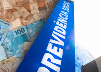 Notas de reais ao lado de fachada do prédio da Previdência Social com o céu ao fundo