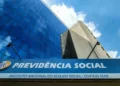 Fachada do Instituto Nacional do Seguro Social com céu azul refletido no prédio de vidro
