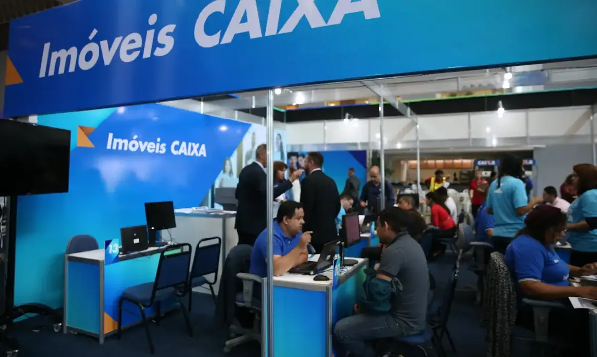 Pessoas solicitando financiamento na Caixa Econômica Federal durante evento do Minha Casa, Minha Vida.