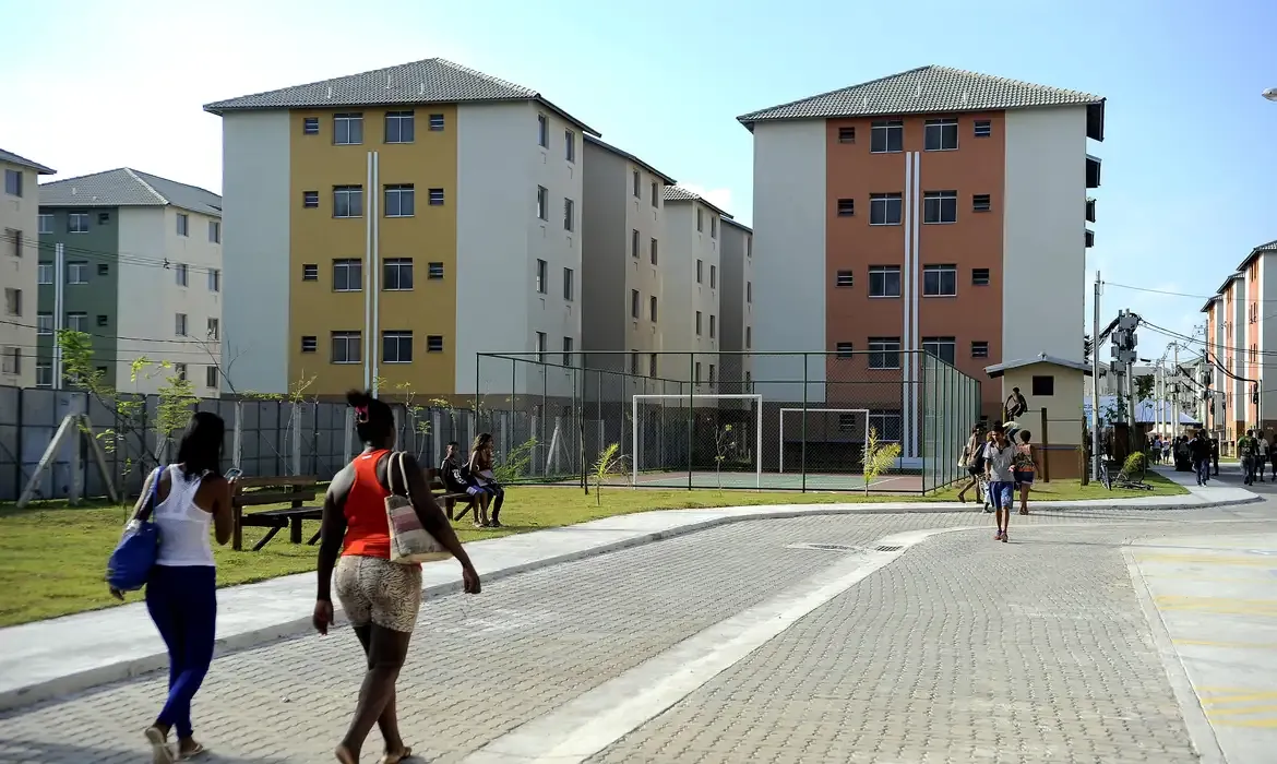 Conjunto habitacional com moradores caminhando e convivendo em área comum.