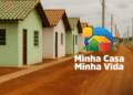 Casas populares alinhadas com o logo colorido do programa Minha Casa Minha Vida, representando oportunidades de moradia para a classe média.