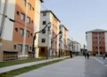 Prédios residenciais com pessoas circulando em área pública de conjunto habitacional.