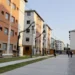 Prédios residenciais com pessoas circulando em área pública de conjunto habitacional.