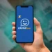 Mão segurando celular com aplicativo Caixa Tem aberto na tela
