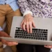 Pessoa idosa usando laptop com ajuda de outra pessoa para acompanhar pedido do Auxílio-doença online