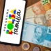 Celular exibindo o logo do Programa Bolsa Família, com notas de 20, 50 e 100 reais ao fundo
