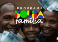 Família feliz segurando cédulas de dinheiro com o logo do Bolsa Família, simbolizando a antecipação de pagamento.