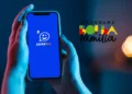 Mãos segurando celular com o aplicativo Caixa Tem aberto, ao lado logo colorida do programa Bolsa Família.