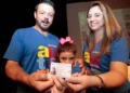 Família feliz segurando a Carteira de Identificação do Autista, mostrando a importância do documento.