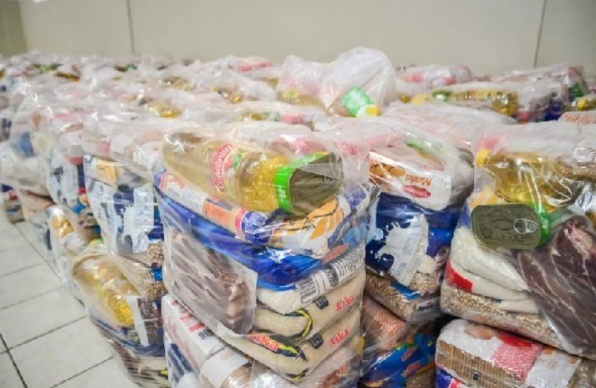 Pacotes de alimentos básicos organizados para distribuição pelo CRAS em 2025.