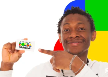 Homem sorrindo e apontando para o cartão do Bolsa Família em um fundo colorido.
