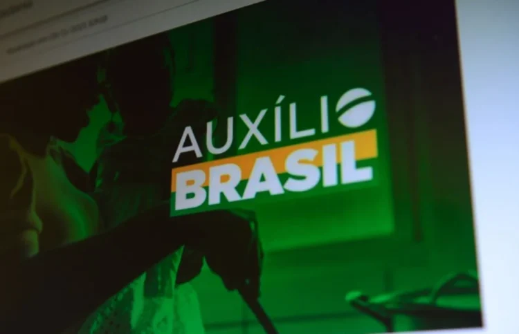 Pessoas consultando informações sobre o programa Auxílio Brasil em um dispositivo eletrônico.