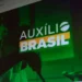 Pessoas consultando informações sobre o programa Auxílio Brasil em um dispositivo eletrônico.