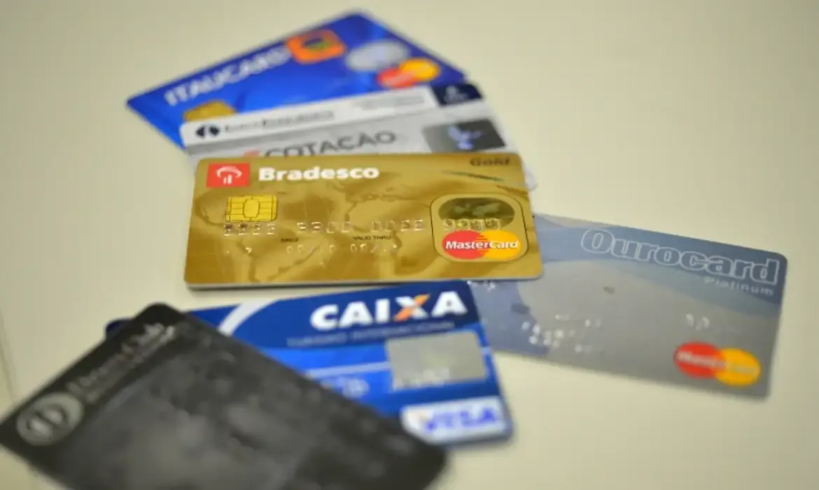 "Diversos cartões de crédito, representando as altas taxas de juros do cartão rotativo"