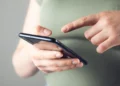 Pessoa usando smartphone para consultar benefícios sociais pelo CPF no app