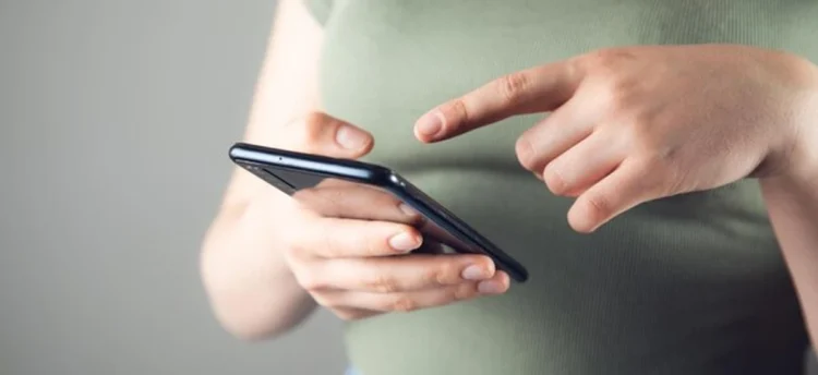 Pessoa usando smartphone para consultar benefícios sociais pelo CPF no app