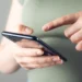 Pessoa usando smartphone para consultar benefícios sociais pelo CPF no app