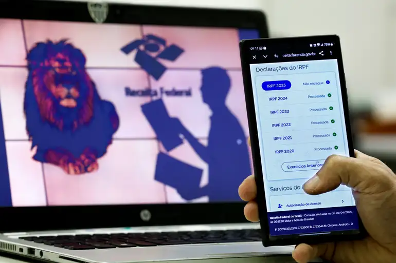 "Pessoa usando o celular para acessar a declaração do Imposto de Renda pré-preenchida"