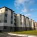 Prédios residenciais modernos para programa de aluguel social em 2025, com céu azul ao fundo.
