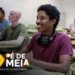 Estudante sorridente em sala de aula usando fones de ouvido, ilustrando o acompanhamento dos pagamentos do programa Pé-de-Meia 2025.