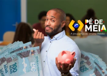 Homem segurando um cofrinho rosa e notas de dinheiro em sala de aula, representando economia para estudantes do ensino médio.