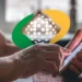 "Idosa usando o celular para acessar informações do INSS, simbolizando o uso do aplicativo Meu INSS para consultar informações importantes sobre benefícios."