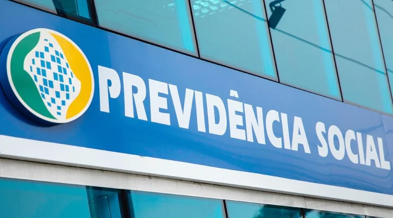 Fachada de uma unidade da Previdência Social com logo do INSS visível, destacando a suspensão dos novos empréstimos consignados.