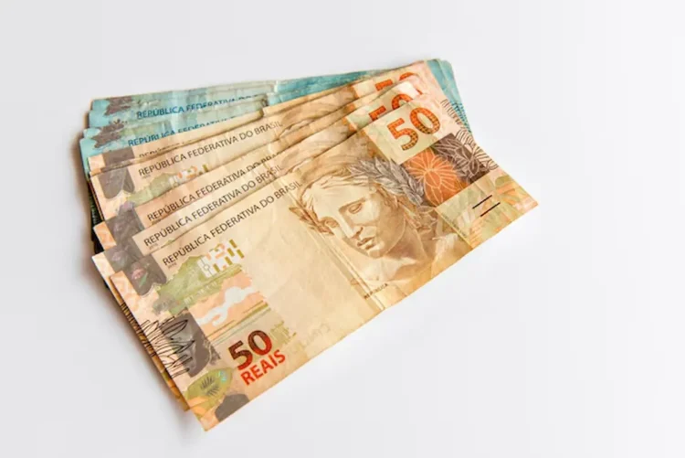 Cédulas de 50 reais simbolizando benefício financeiro liberado no Brasil.
