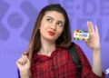 Estudante segurando o cartão do programa Pé-de-Meia, com fundo colorido e a logo do programa.