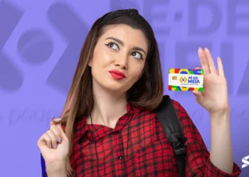 Estudante segurando o cartão do programa Pé-de-Meia, com fundo colorido e a logo do programa.