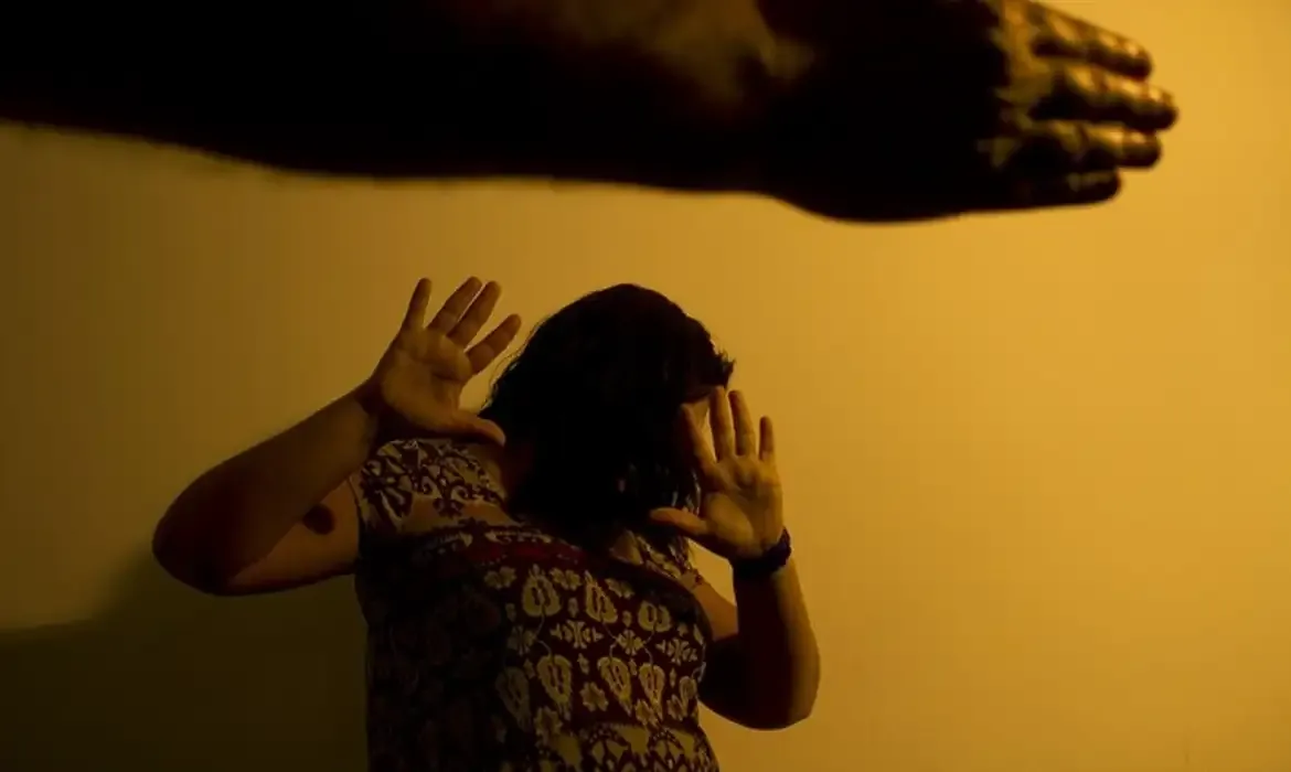  Mulher se defendendo de agressão com as mãos levantadas