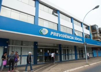 Fachada do INSS com pessoas entrando para solicitar prorrogação do auxílio-doença.