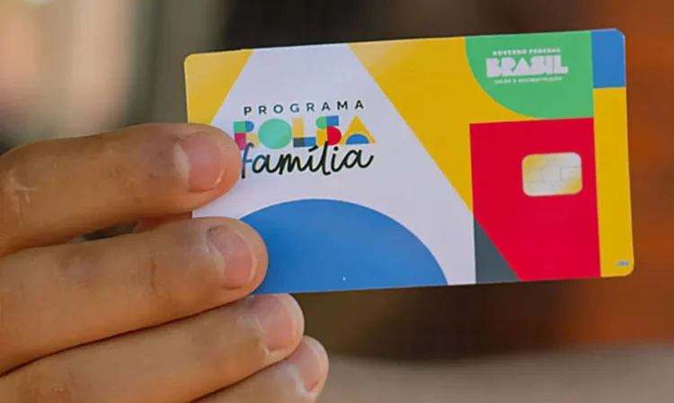 "Cartão do Programa Bolsa Família sendo segurado por uma pessoa, representando a transição tranquila para o mercado de trabalho."