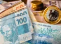 Dinheiro em notas e moedas de real representando reajuste de benefício no Brasil