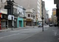 Rua deserta durante o feriado de 20 de novembro, com lojas fechadas, refletindo a aplicação do ponto facultativo.