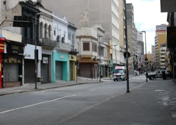 Rua deserta durante o feriado de 20 de novembro, com lojas fechadas, refletindo a aplicação do ponto facultativo.