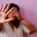 Mulher com a mão levantada em sinal de pare, simbolizando recusa à violência